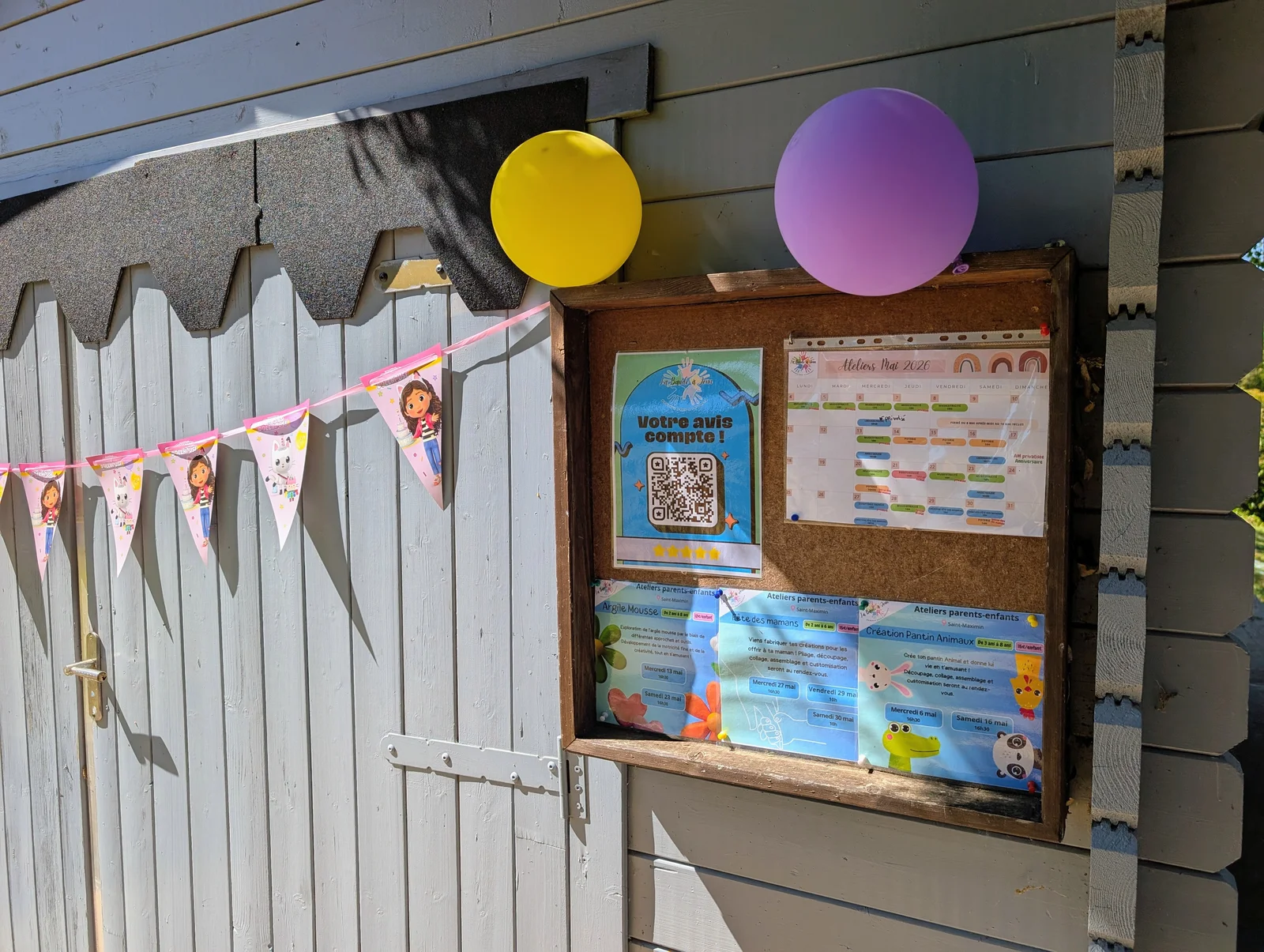 Entrée du local d'atelier avec planning, QR code avis et ballons