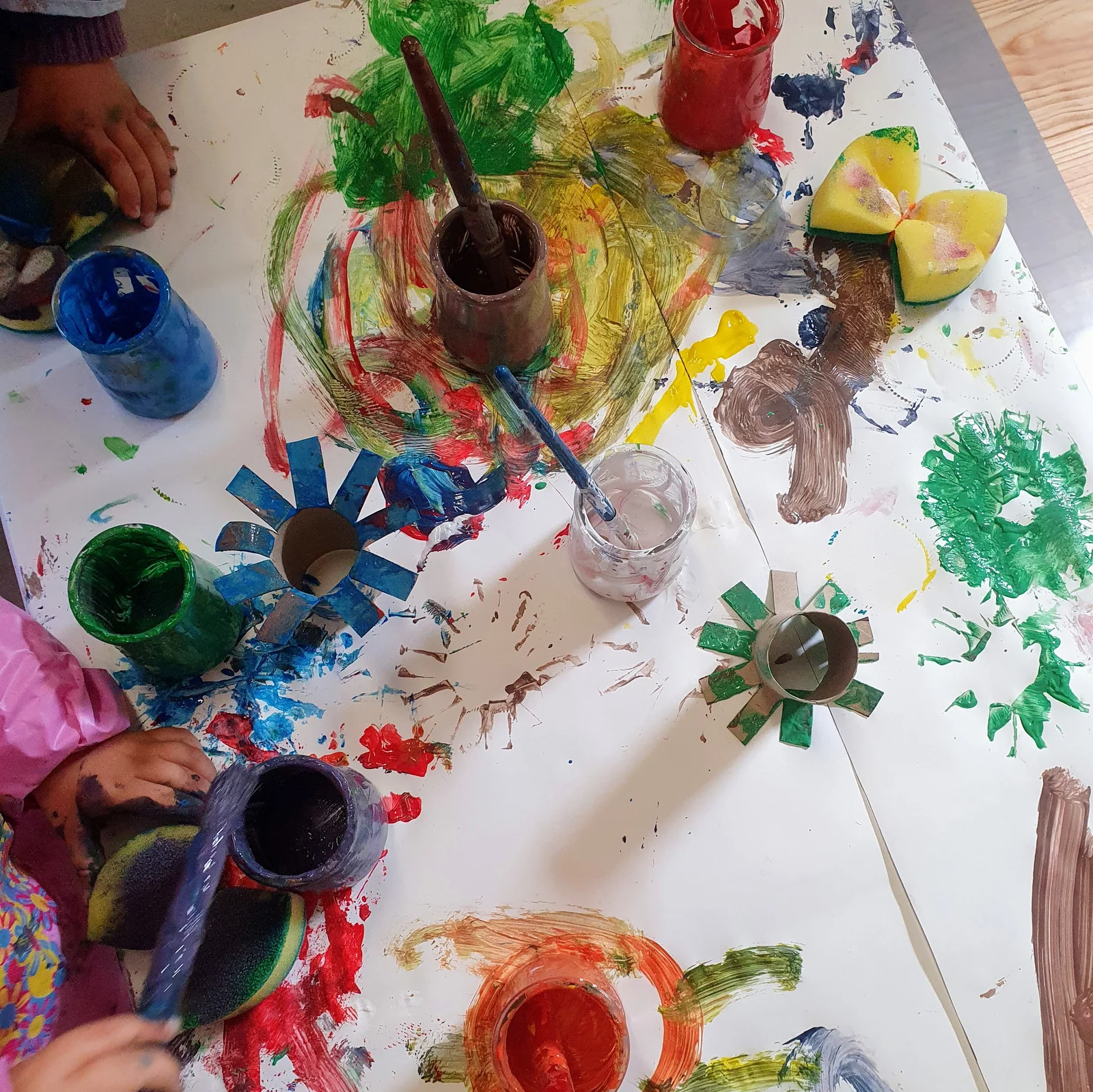 Peinturosité : feuille couverte de couleurs vives et pots de peinture