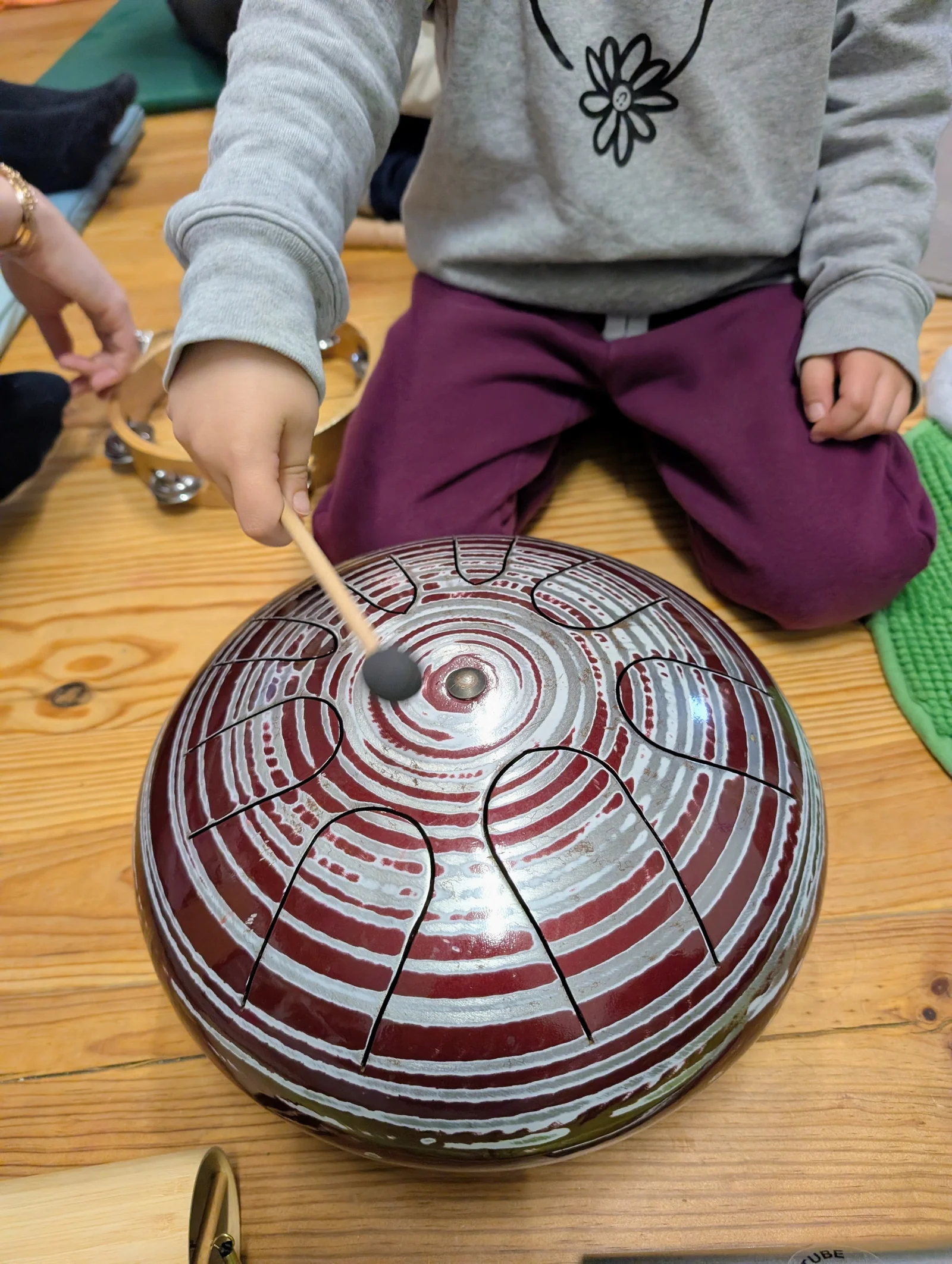 Musicotricité : enfant jouant du tambour à langues métallique